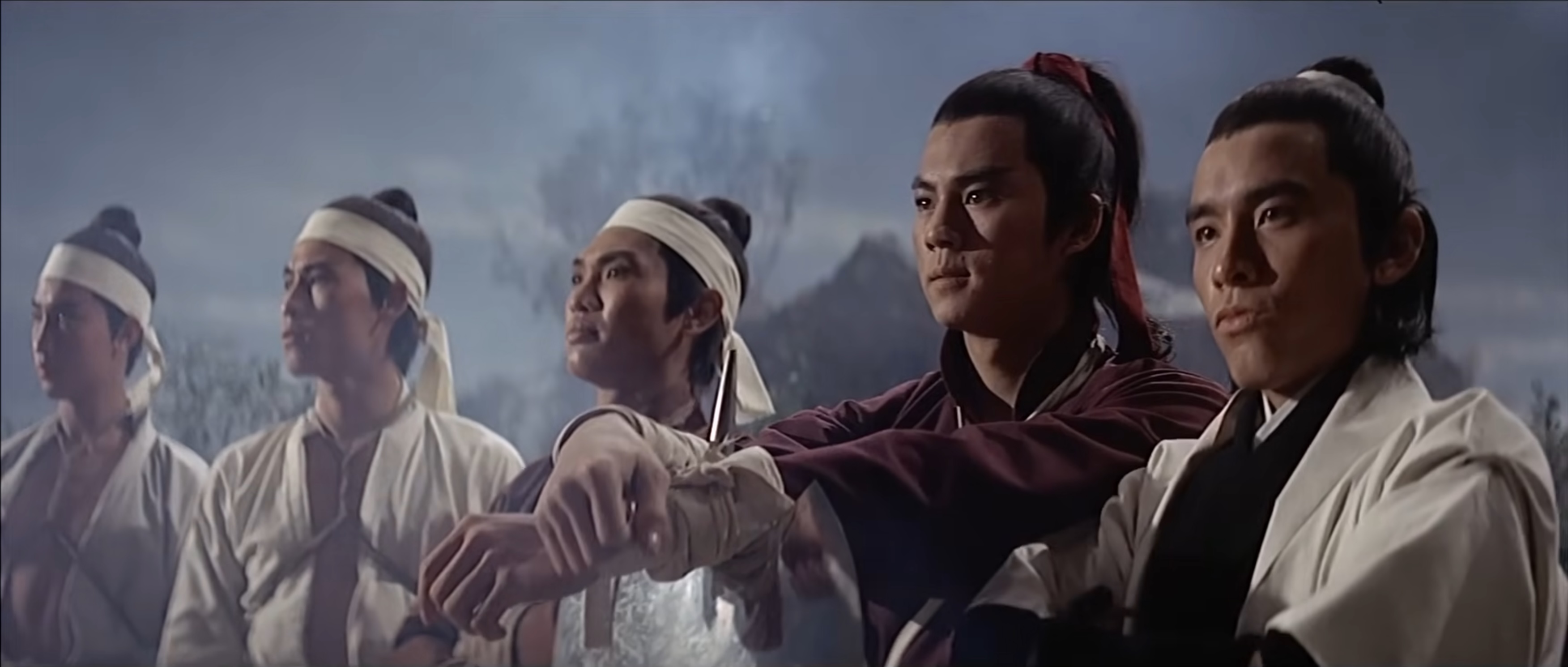 Five men stand in a line, looking confident and brave. The two men in the foreground are Ti Lung, leaning on an axe, and David Chiang, wearing a white robe.
